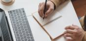 Person writing on notebook